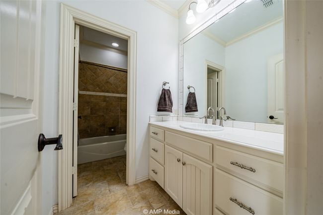 Bathroom featuring vanity, ornamental molding, and tiled shower / bath combo | Image 28