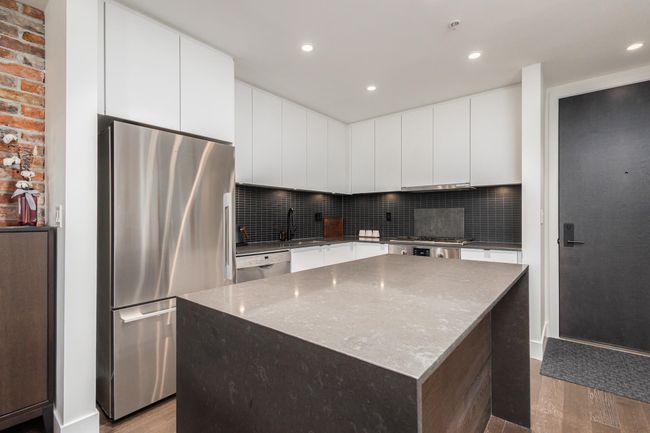 Kitchen featuring stainless steel appliances, wood finished floors, backsplash, a center island, and recessed lighting | Image 16