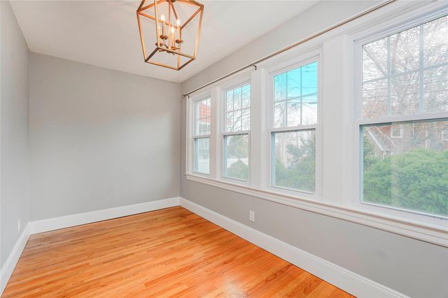 Unfurnished room with baseboards, a chandelier, and light wood-style floors | Image 6