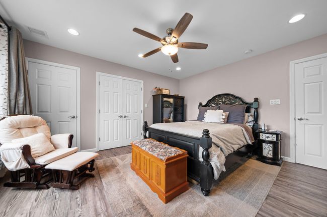 Bedroom with baseboard heating, baseboards, wood finished floors, crown molding, and recessed lighting | Image 26