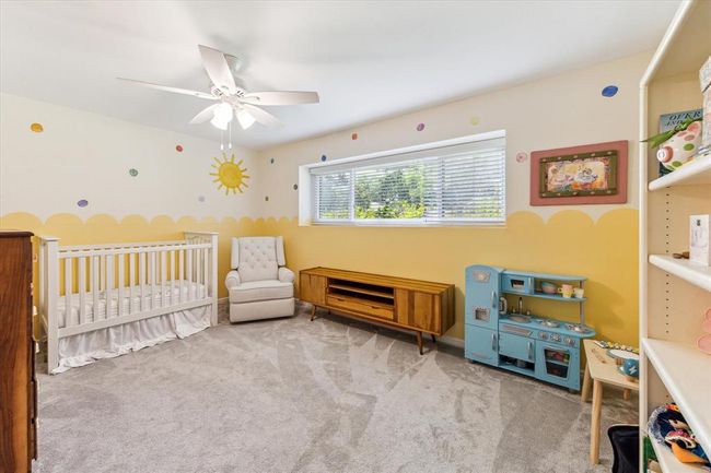 Bright secondary bedroom at the front of the home features a large window, inviting abundant natural light. | Image 15