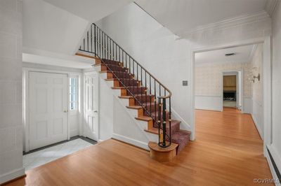 Front Entry with custom medal stair rail and spindles with brass handrail. View is into the Dining Room. | Image 3