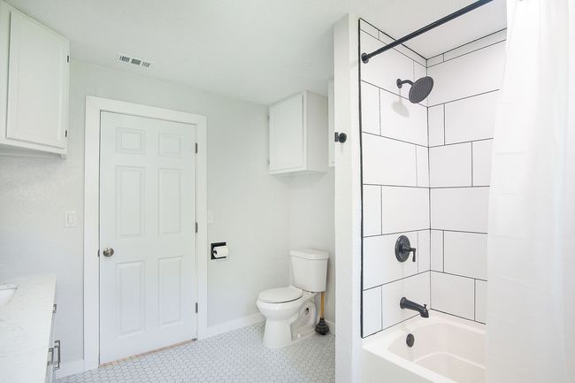 Bathroom with shower / tub combo with curtain, tile patterned floors, and vanity | Image 20