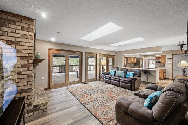 The main family room with wonderful floor to ceiling glass door and windows which provide a breathtaking view of the very private backyard. New luxury vinyl flooring was added! | Image 12
