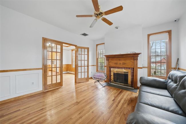 Living room with light wood-style floors, visible vents, a wainscoted wall, and a wealth of natural light | Image 24