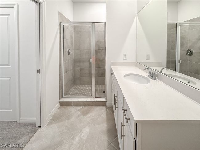 Full bathroom featuring a shower stall, vanity, and baseboards | Image 28