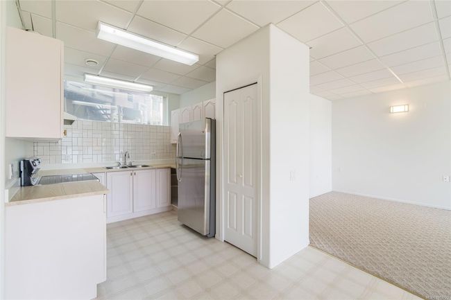 Kitchen featuring appliances with stainless steel finishes, a sink, light countertops, a paneled ceiling, and white cabinetry | Image 44