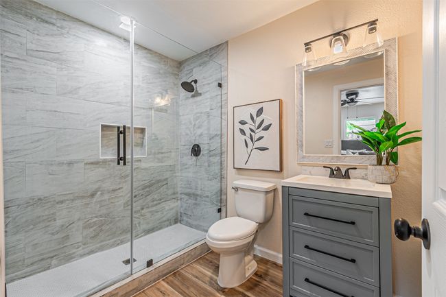 Full bath with vanity, wood finished floors, a shower stall, and toilet | Image 15