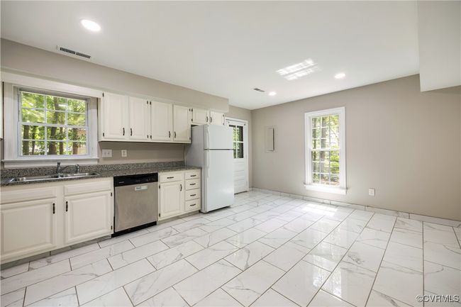 Kitchen with dishwasher, freestanding refrigerator, white cabinets, light marble finish floors, and recessed lighting | Image 10