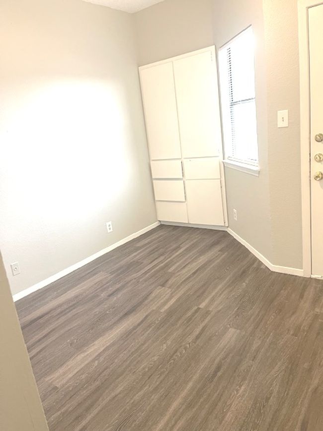 Unfurnished bedroom featuring dark wood-style flooring and baseboards | Image 8