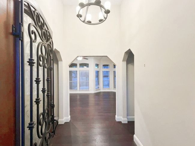 Foyer entrance featuring a high ceiling, dark hardwood / wood-style flooring, and an inviting chandelier | Image 4