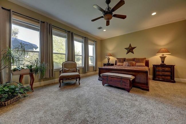 Full wall of windows overlooking the grove of trees and improved pasture. The Primary Suite is approximately 950sf per Seller. | Image 22