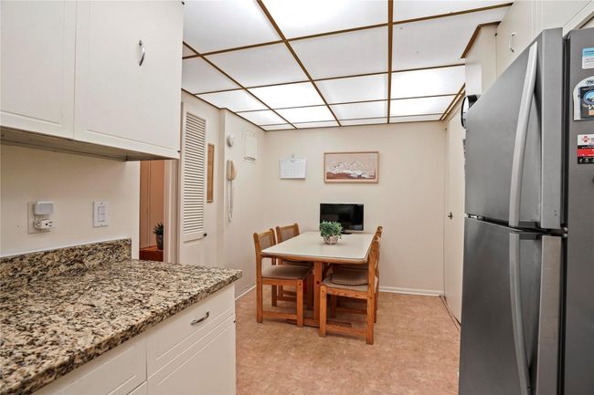 Kitchen featuring white cabinetry, stone counters, and stainless steel refrigerator | Image 12