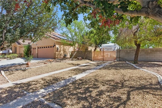 View of front of property with a gate, fence private yard, a garage, stucco siding, and solar panels | Image 46