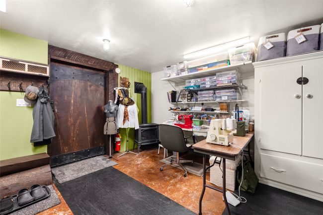 Office area featuring a wood stove and finished concrete floors | Image 30