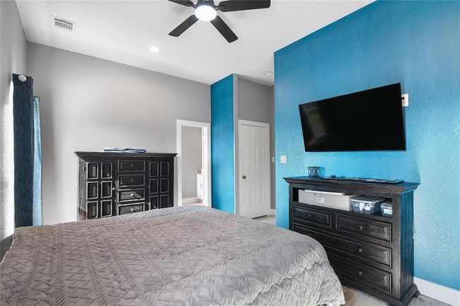 Luxurious primary bedroom featuring a modern design with a soothing color palette, ample natural light, and sleek furnishings. | Image 9