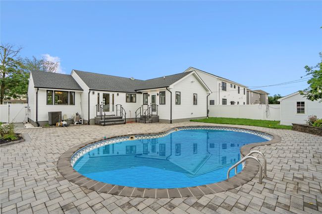 View of pool with a gate, a fenced backyard, and a patio area | Image 34