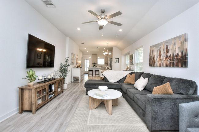 Living room featuring ceiling fan with notable chandelier, light wood-type flooring, visible vents, recessed lighting, and baseboards | Image 8