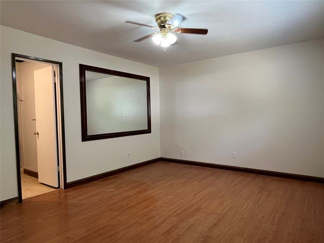 Empty room featuring light wood-style flooring, a ceiling fan, and baseboards | Image 7
