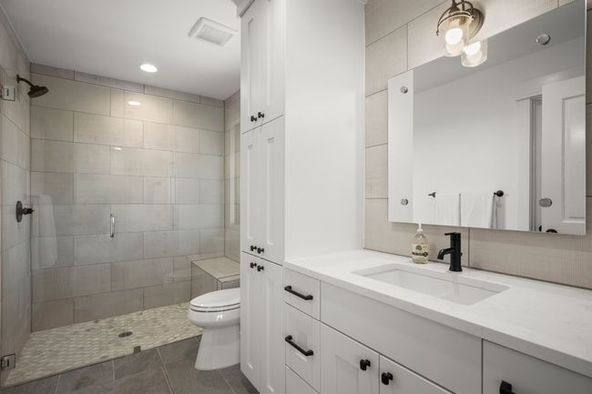 Upstairs full bathroom has large walk-in shower and ample storage. | Image 25