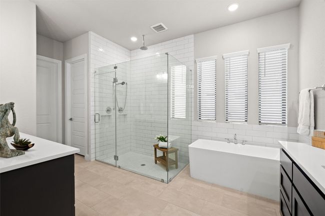 Bathroom with a stall shower, a freestanding bath, vanity, recessed lighting, and tile patterned floors | Image 24