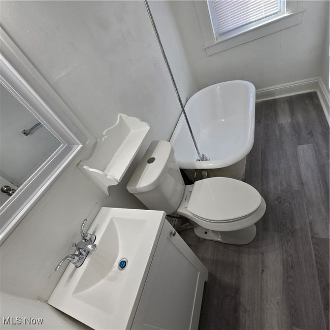 Bathroom with wood finished floors, vanity, toilet, and baseboards | Image 9