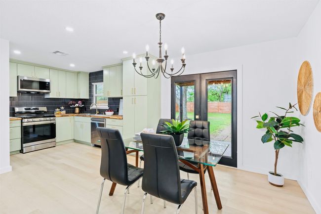 Dining area with light wood finished floors, a chandelier, and recessed lighting | Image 9