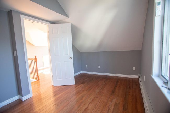 Additional living space featuring vaulted ceiling, baseboard heating, and dark wood-type flooring | Image 22