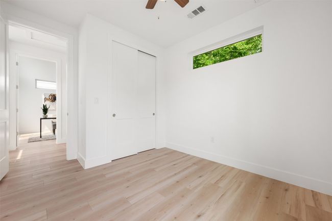 Unfurnished bedroom featuring light wood finished floors, a closet, baseboards, and ceiling fan | Image 23