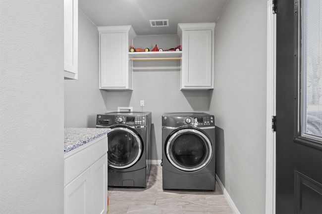 Laundry room with independent washer and dryer, visible vents, cabinet space, and baseboards | Image 31