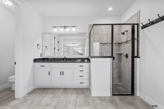 Bathroom with a stall shower, vanity, and recessed lighting | Image 19