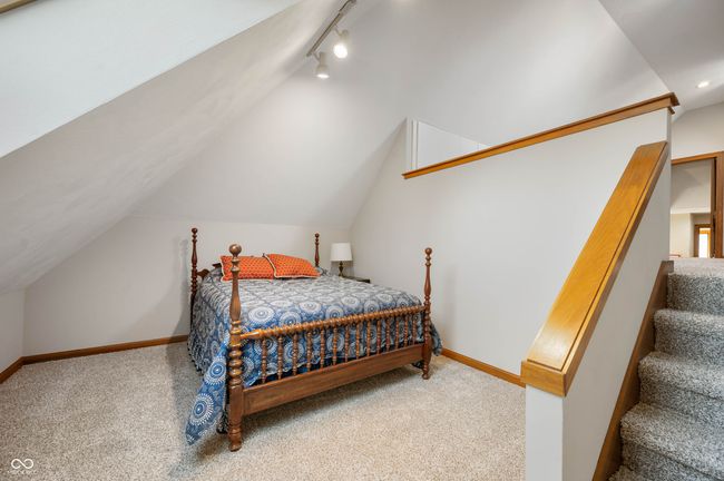 carpeted bedroom featuring lofted ceiling, rail lighting, and baseboards | Image 30