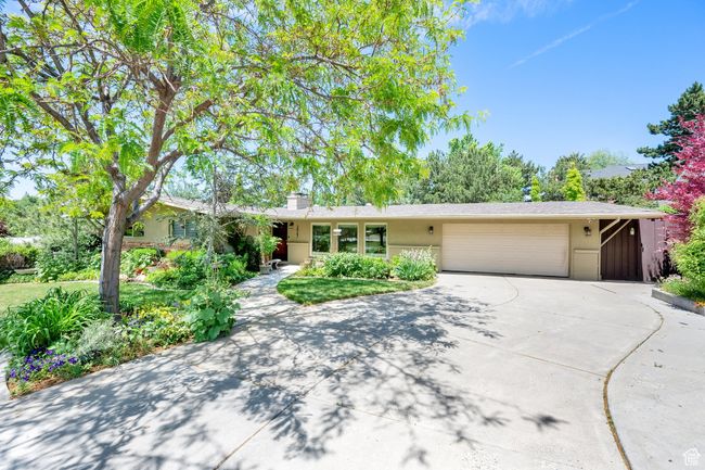 Ranch-style home featuring driveway, an attached garage, a chimney, and stucco siding | Image 40