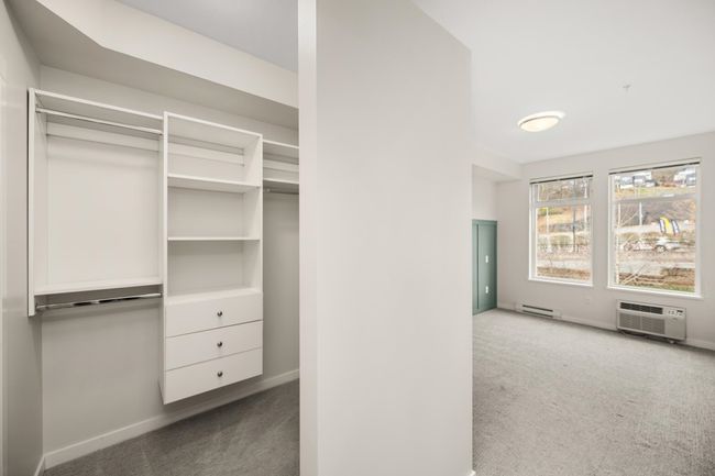 Closet featuring baseboard heating and a wall mounted air conditioner | Image 21