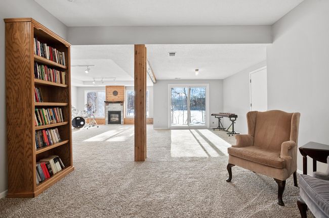 The lower level amusement room has a walkout to the backyard and lake. Step outside and enjoy a canoe or kayak ride in the summer or skating and cross country skiing in the winter. | Image 29