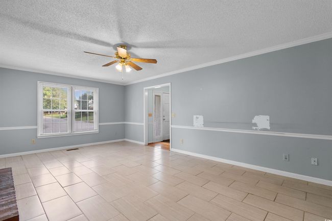 Spare room featuring a ceiling fan, a textured ceiling, and crown molding | Image 12