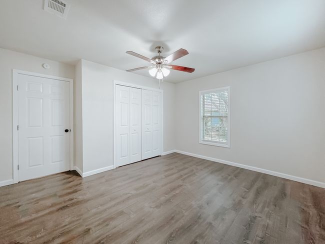 Unfurnished bedroom with wood finished floors, a closet, and ceiling fan | Image 19