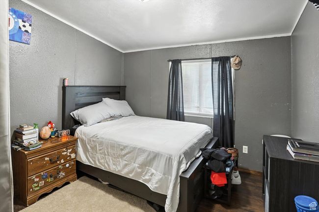 Bedroom with a textured wall and wood finished floors | Image 14