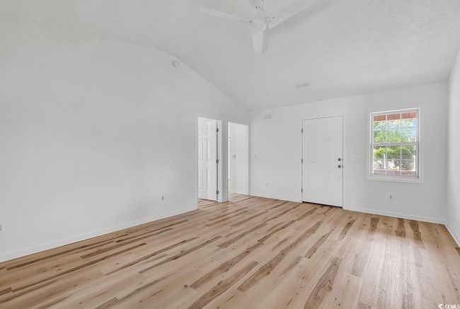Interior space with a ceiling fan, baseboards, vaulted ceiling, and light wood-type flooring | Image 8
