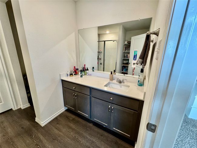 Full bath with wood finished floors, vanity, a stall shower, and baseboards | Image 8