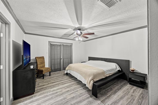 Spacious bedroom and ceiling fan. Neutral colors and ample natural light create a serene atmosphere. | Image 27