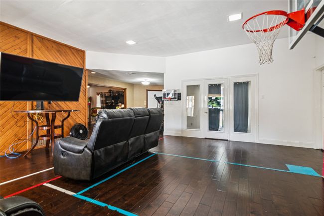 Living room with wood-type flooring and wooden walls | Image 9