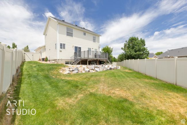Rear view of house featuring a wooden deck, a fenced backyard, a gate, and stairway | Image 25