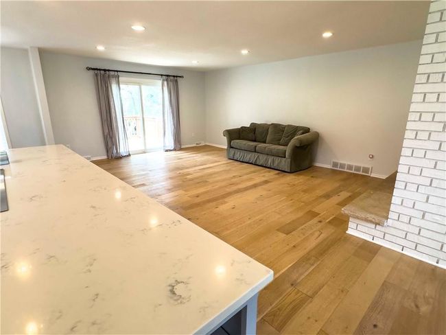 Living area with visible vents, baseboards, light wood finished floors, and recessed lighting | Image 15