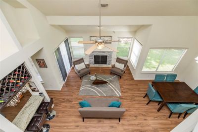 Spacious Living/Dining area with laminate floors, high ceiling, wood burning fireplace, wet-bar that is open to the study | Image 1