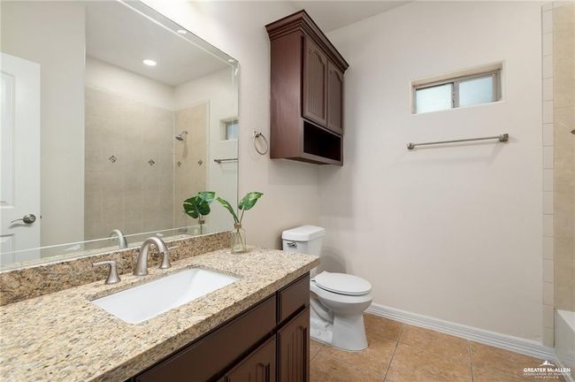 Unfurnished bedroom featuring light tile patterned flooring, a closet, a ceiling fan, and a tray ceiling | Image 13