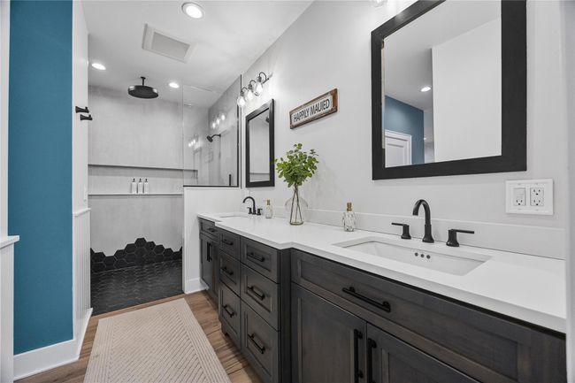 Full bathroom featuring wood finished floors, a sink, a walk in shower, and visible vents | Image 24