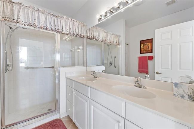 Master Bathroom with an enclosed shower, tile flooring, vanity with extensive cabinet space, and dual sinks | Image 22