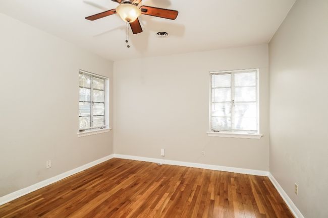 Unfurnished room with healthy amount of natural light, wood finished floors, and ceiling fan | Image 15