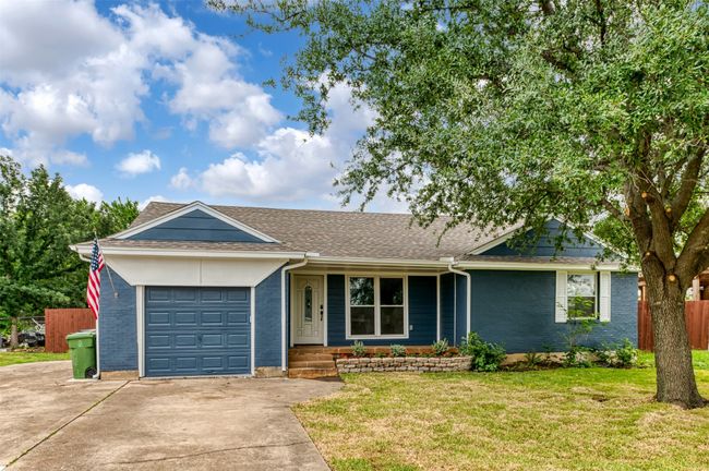 Ranch-style home with a garage, concrete driveway, roof with shingles, and covered porch | Image 31
